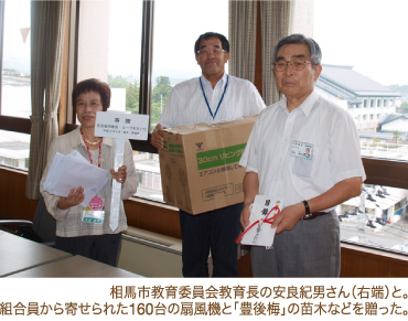 相馬市教育委員会教育長の安良紀男さん（右端）と。組合員から寄せられた160台の扇風機と「豊後梅」の苗木などを贈った。